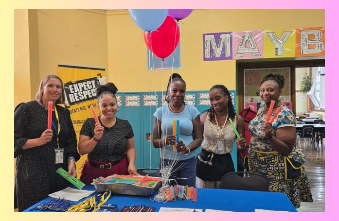  5 adults holding popsicles in front of a table